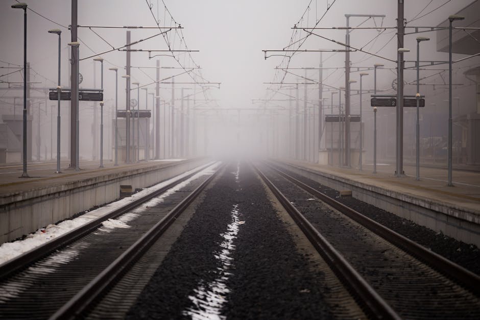 Misty railway platform enveloped in fog at a winter station.